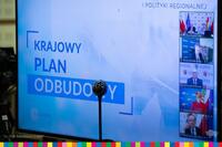Slajd z prezentacji wyświetlany na monitorze. Na slajdzie znajduje się napis: Krajowy Plan Odbudowy.